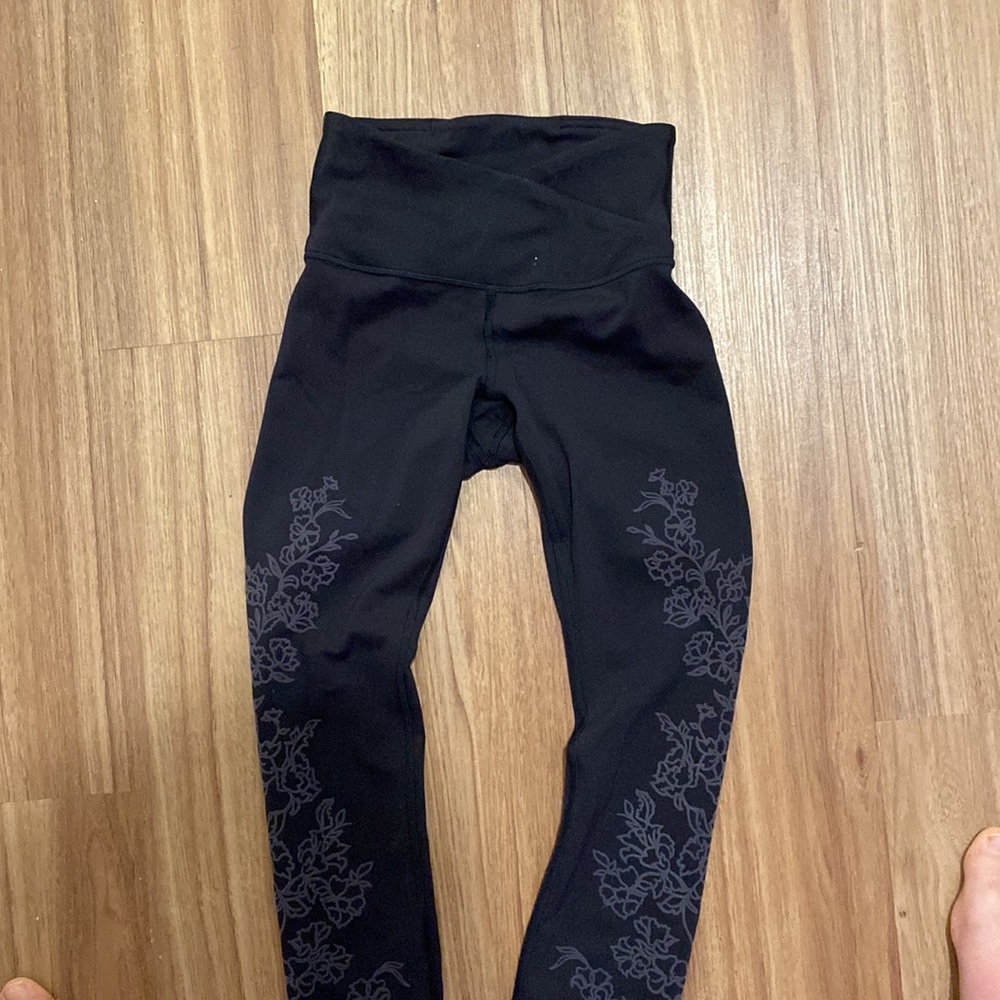 lululemon black leggings with flower embossing on both legs below the knee